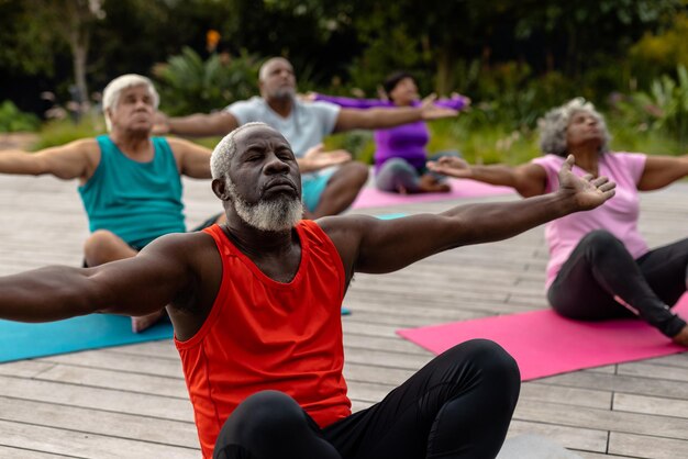 multiracial-senior-friends-with-eyes-closed-arms-outstretched-meditating-mats-yard-together-yoga-zen-unaltered-support-assisted-living-retirement-fitness-active-lifestyle-concept_13339-335353